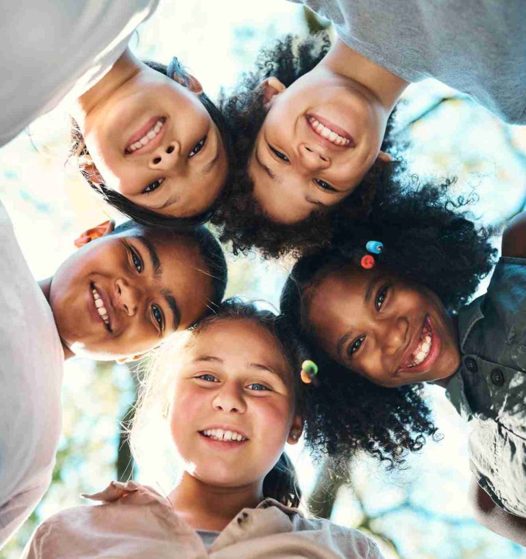 Shot of a group of teenagers standing in a circle in nature at summer camp.